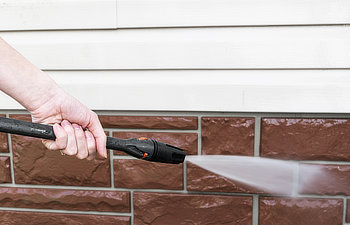 cleaning service washing building facade with pressure water