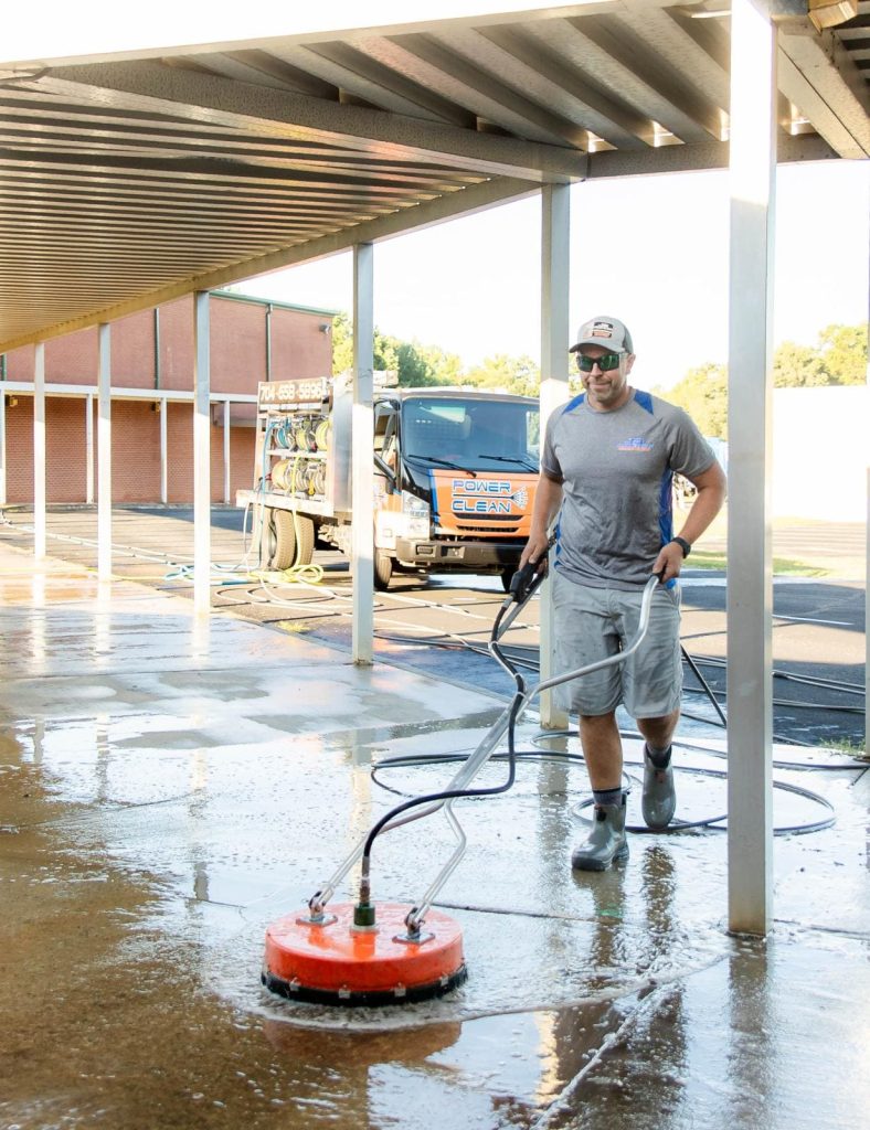 JB Power Clean commercial pressure washing – worker cleaning school grounds