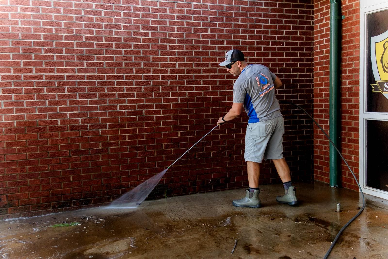 JB Power Clean commercial pressure washing – worker cleaning school grounds