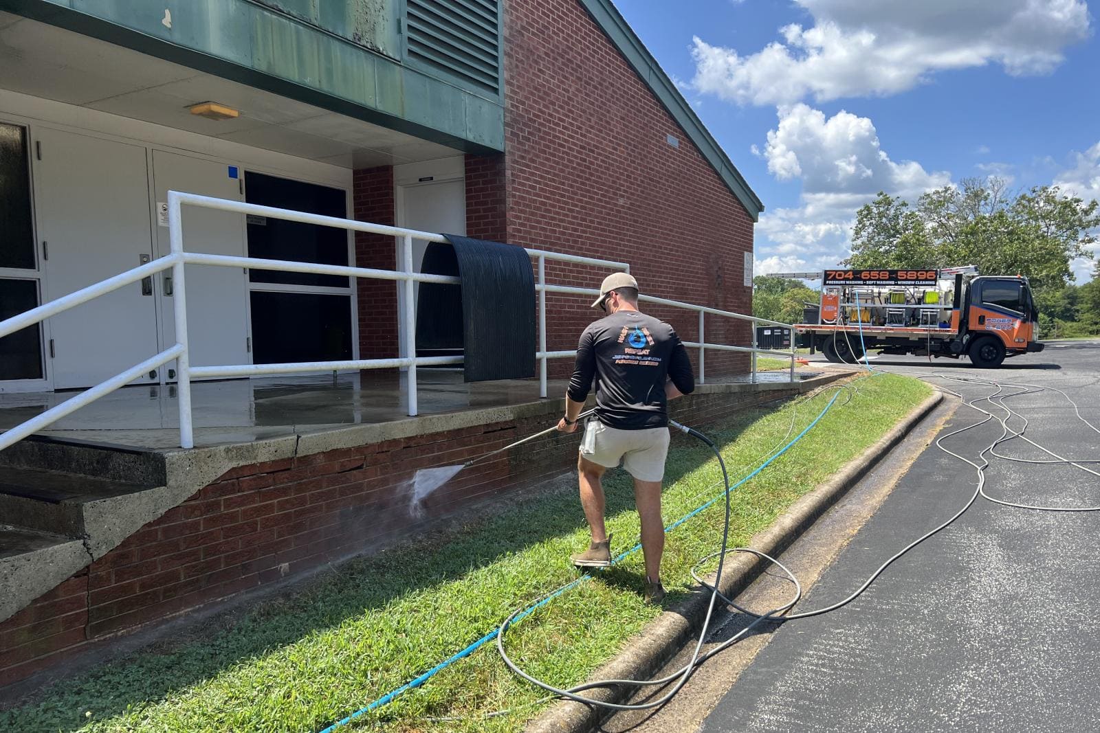 JB Power Clean commercial pressure washing – worker cleaning school grounds