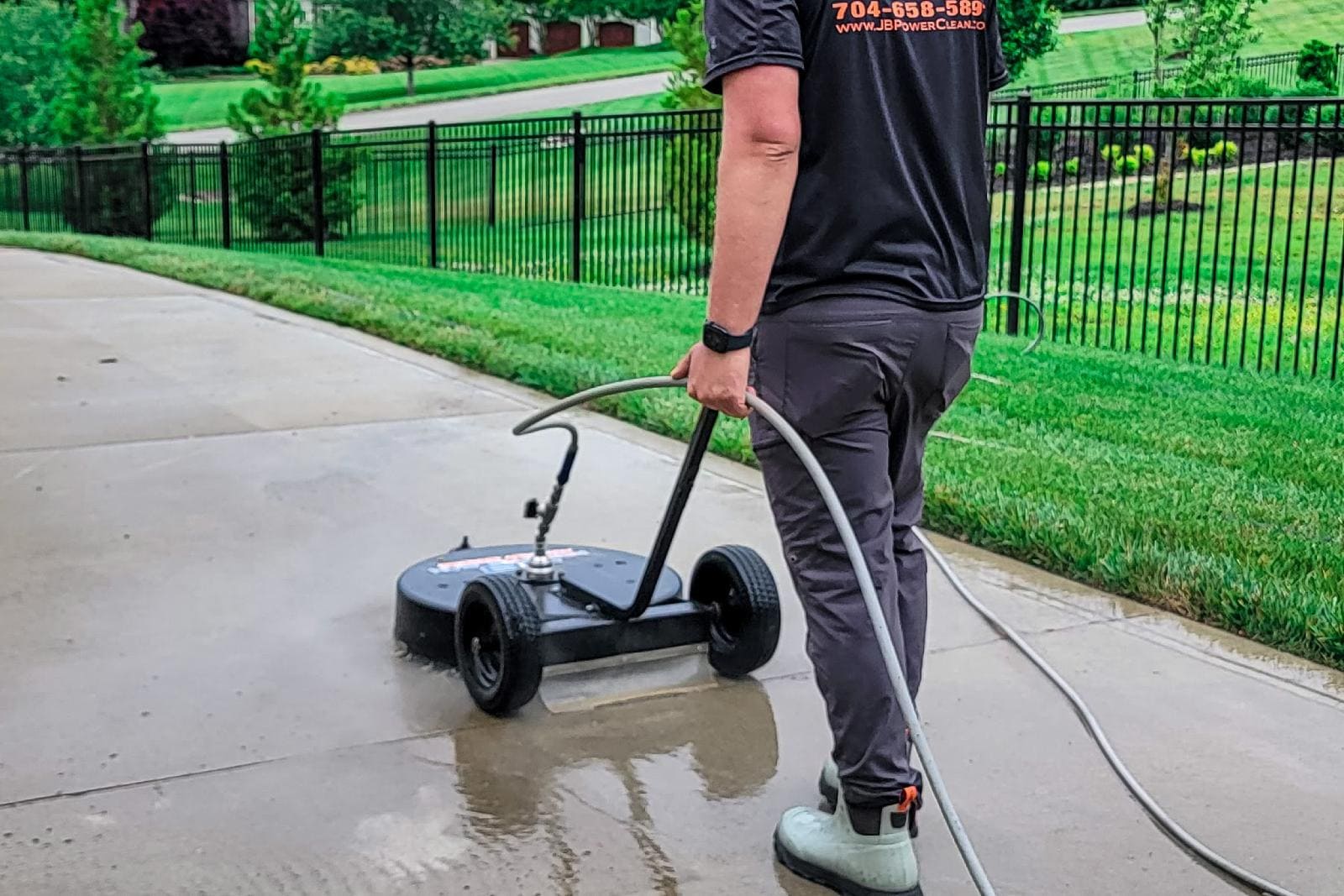 JB Power Clean pressure washing – worker cleaning residential driveway