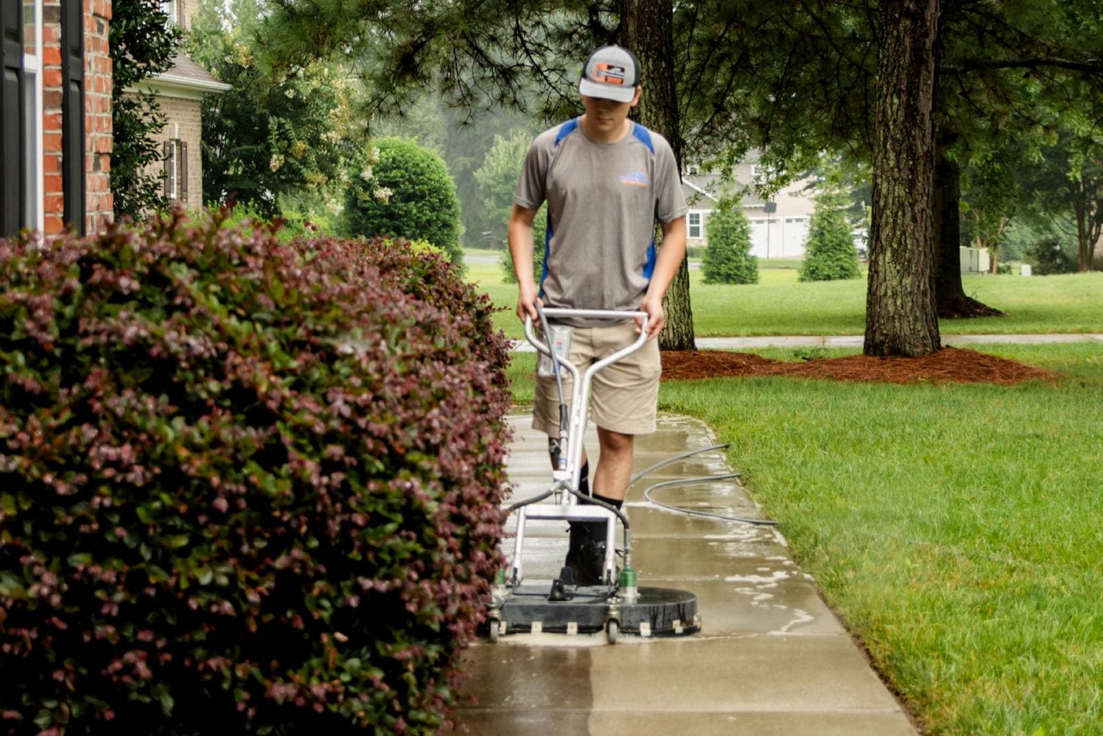 JB Power Clean pressure washing – worker cleaning residential sidewalk