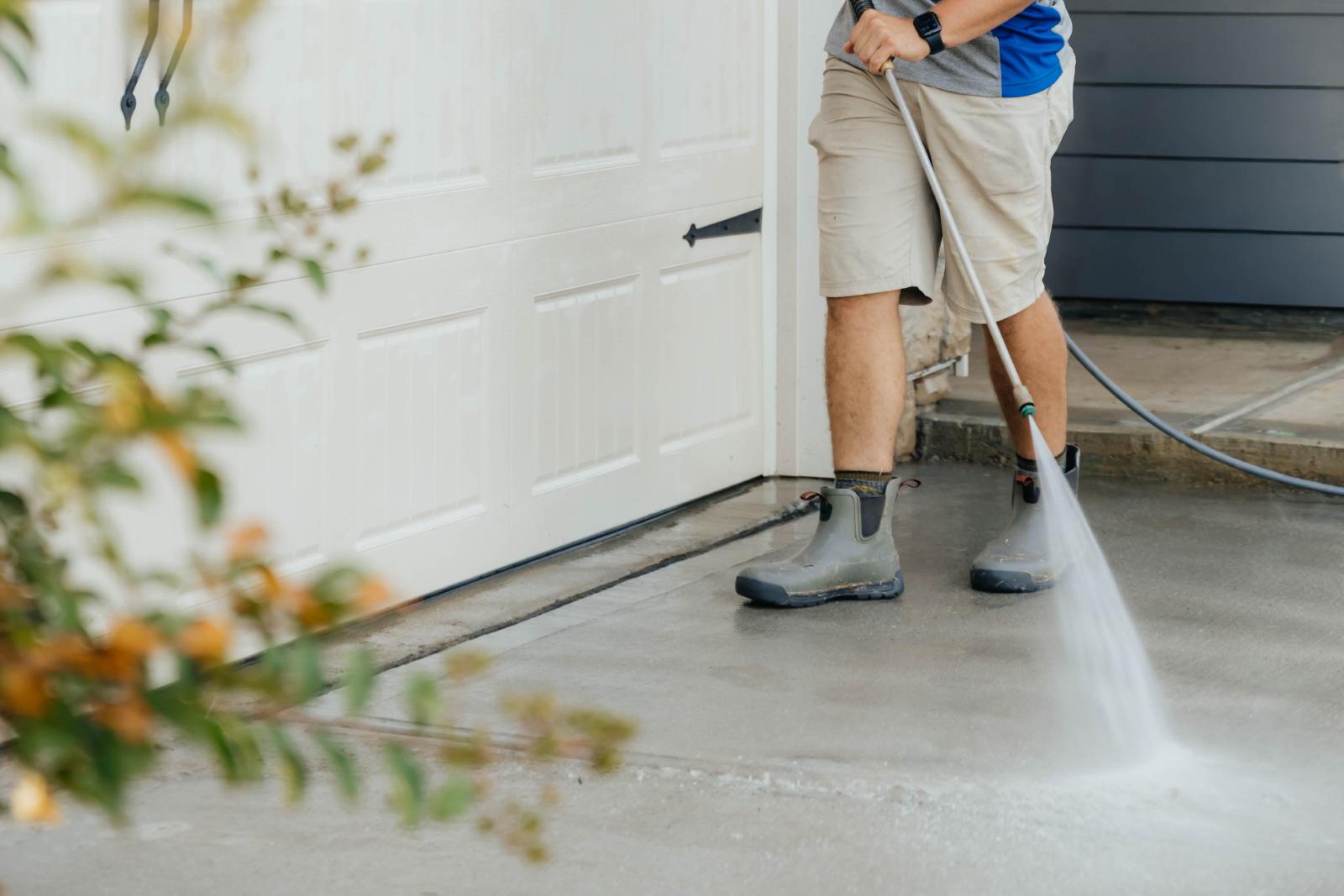JB Power Clean pressure washing – worker cleaning residential driveway