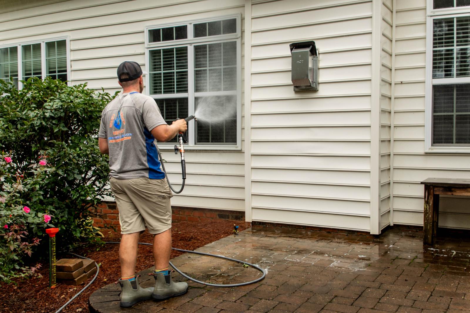 JB Power Clean technician using pressure washer for residential window cleaning