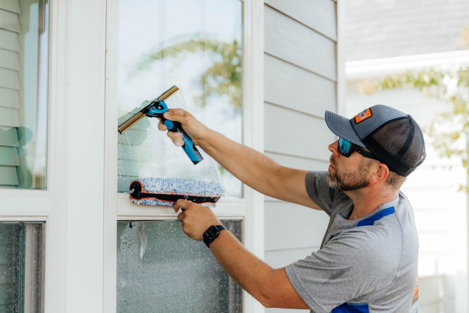 JB Power Clean technician performing professional residential window cleaning